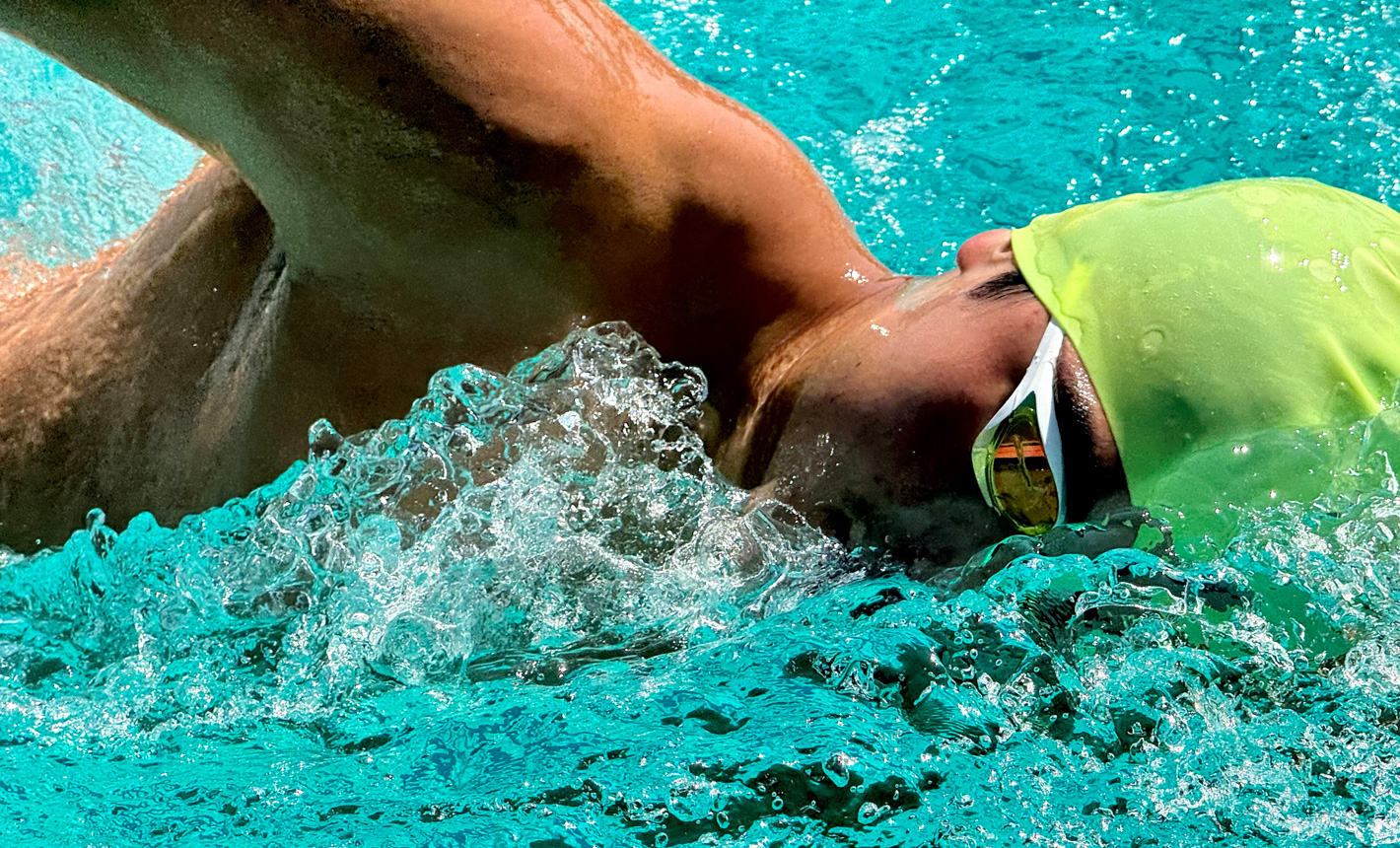 水しぶきをあげながらプールで泳ぐ人をズームで撮影した非常に精細な写真